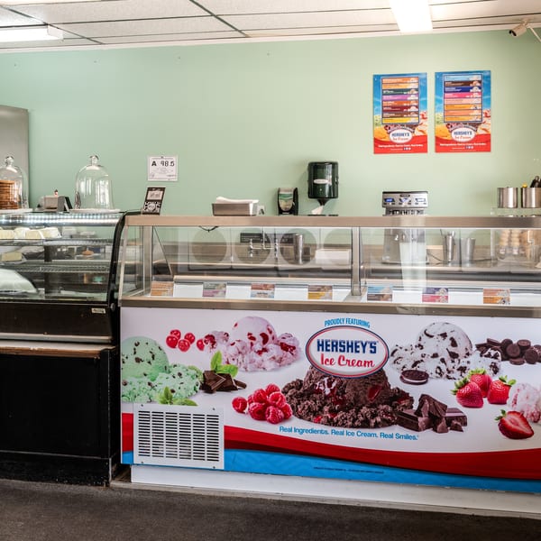 An ice cream shop interior with a Hershey's Ice Cream display case and a pastry case.