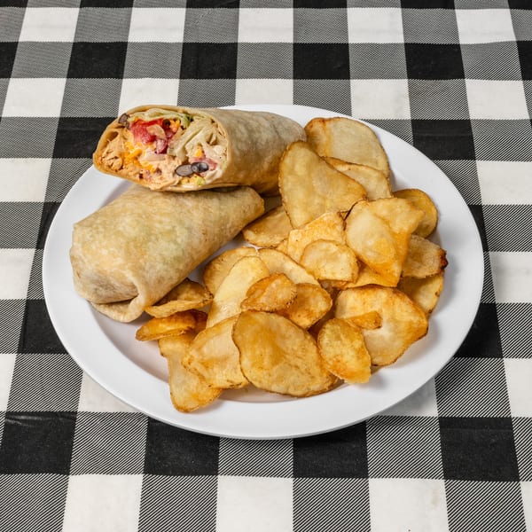 Two wraps with chicken, beans, and vegetables, served with potato chips on a white plate.