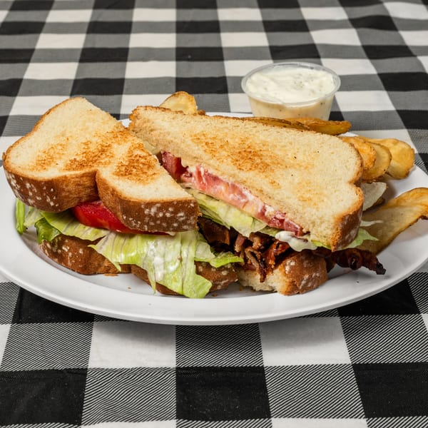 BLT sandwich with crispy bacon, lettuce, tomato, and mayonnaise, served with potato chips and dip.