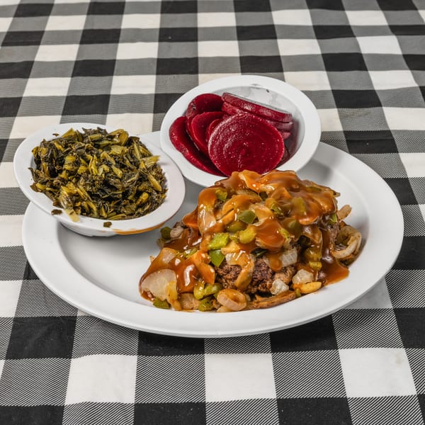 Salisbury steak with gravy, onions, and peppers, served with collard greens and sliced beets.